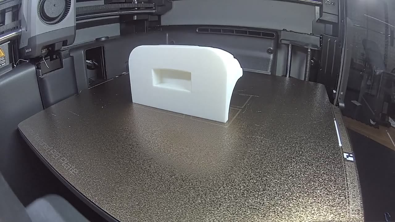 A curved white 3D-printed housing part with a recessed handle