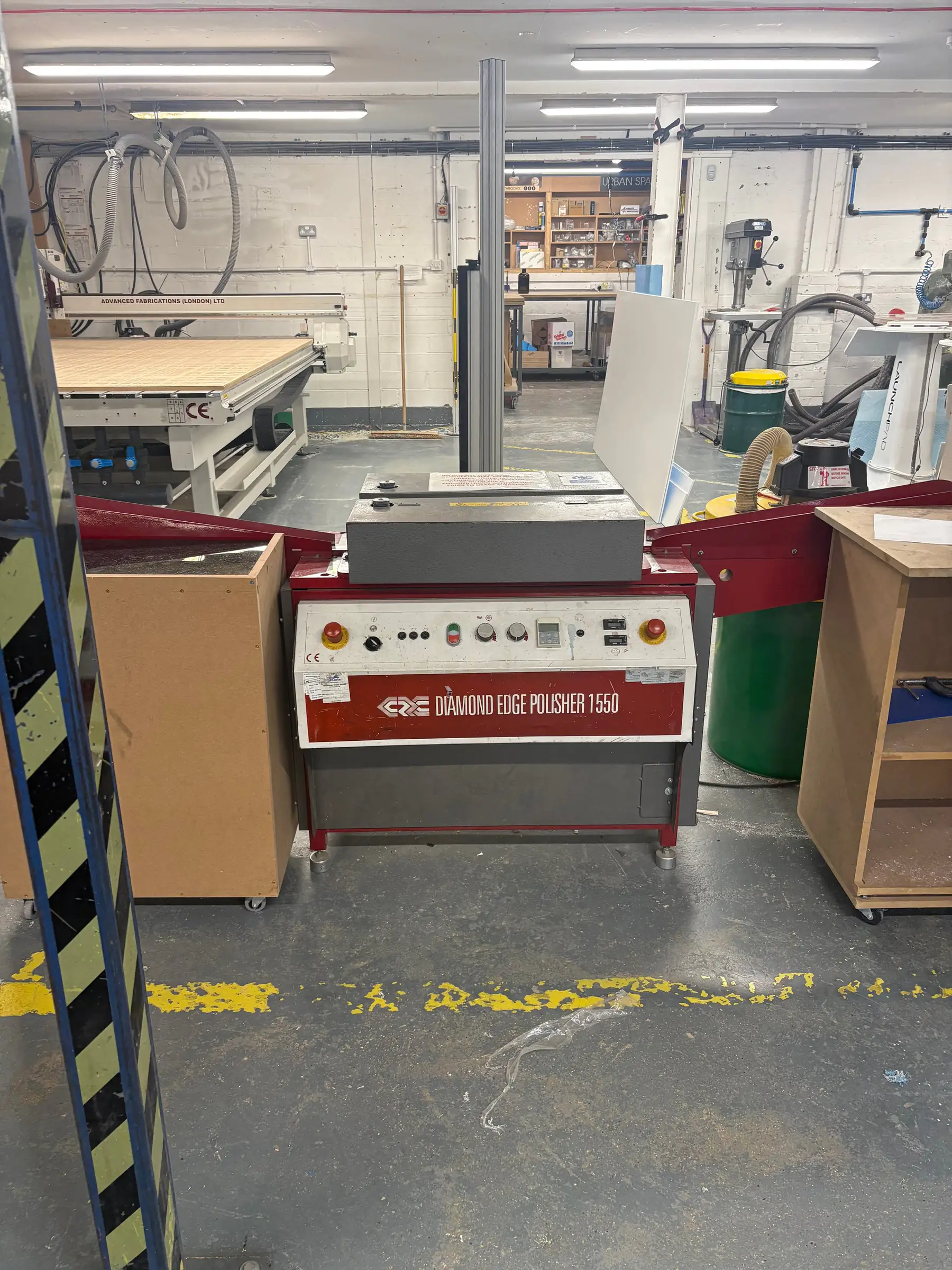 The diamond edge polisher on the Advanced Fabrications shop floor, with the CNC bed and the workshop behind it