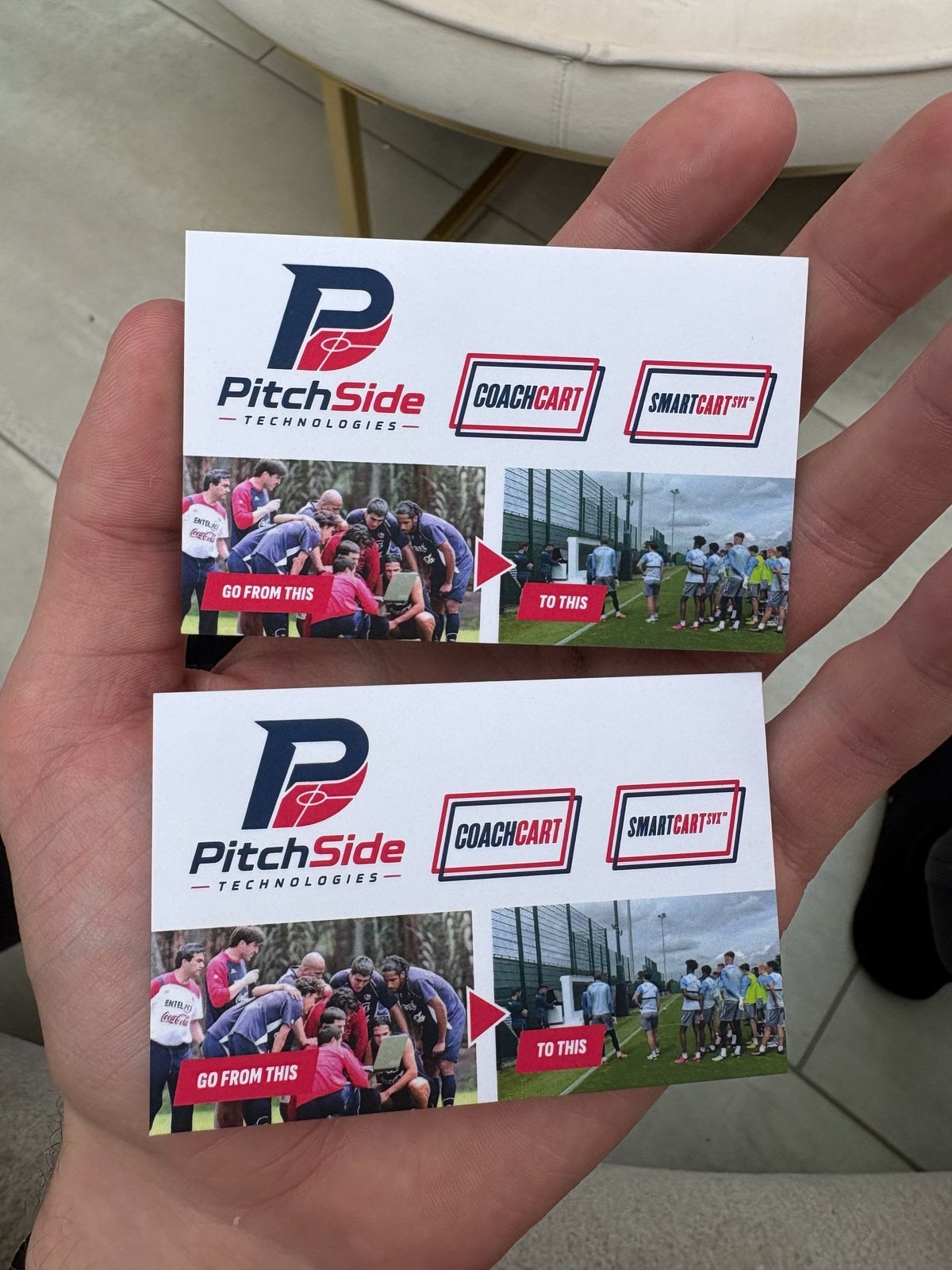 Two PitchSide Technologies business cards held in a hand